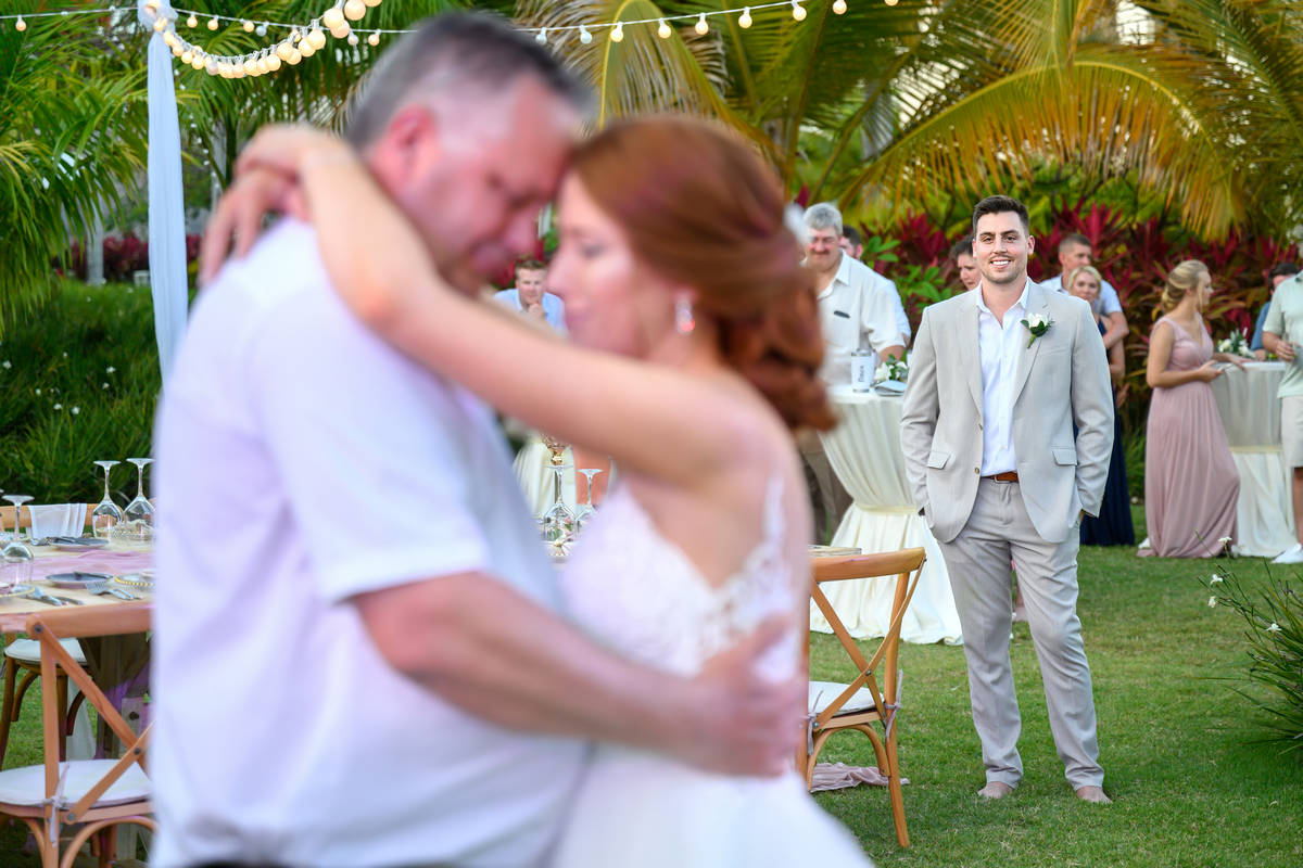 Groom looking at bride and dad dance at Secrets Cap Cana