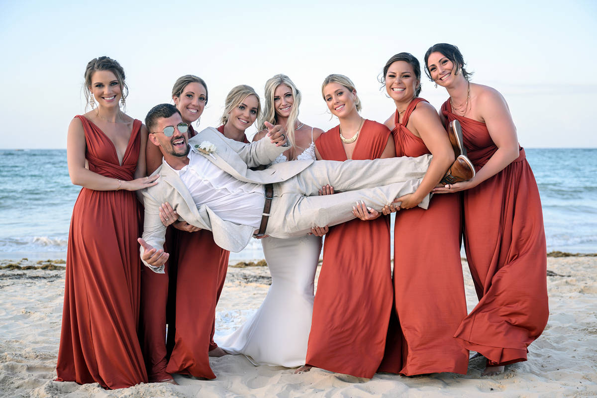 bridesmaids holding groom