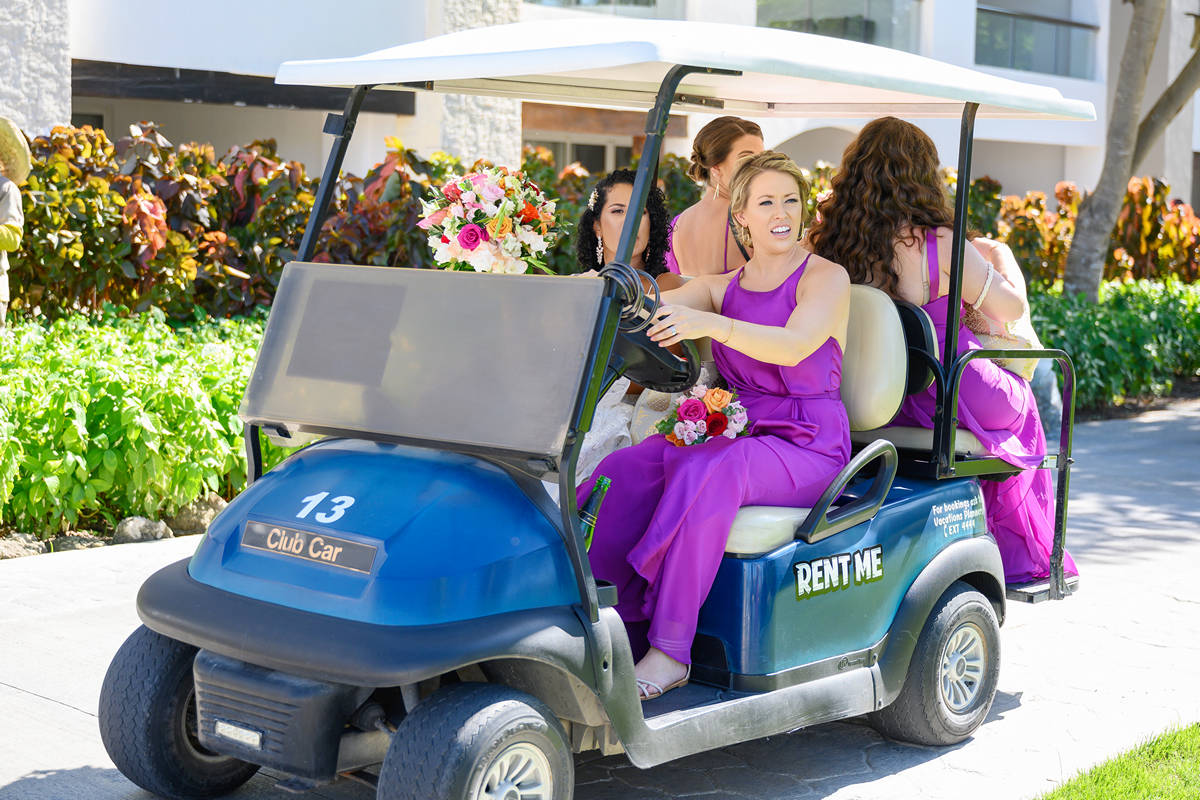bride with bridesmaids at golf cart