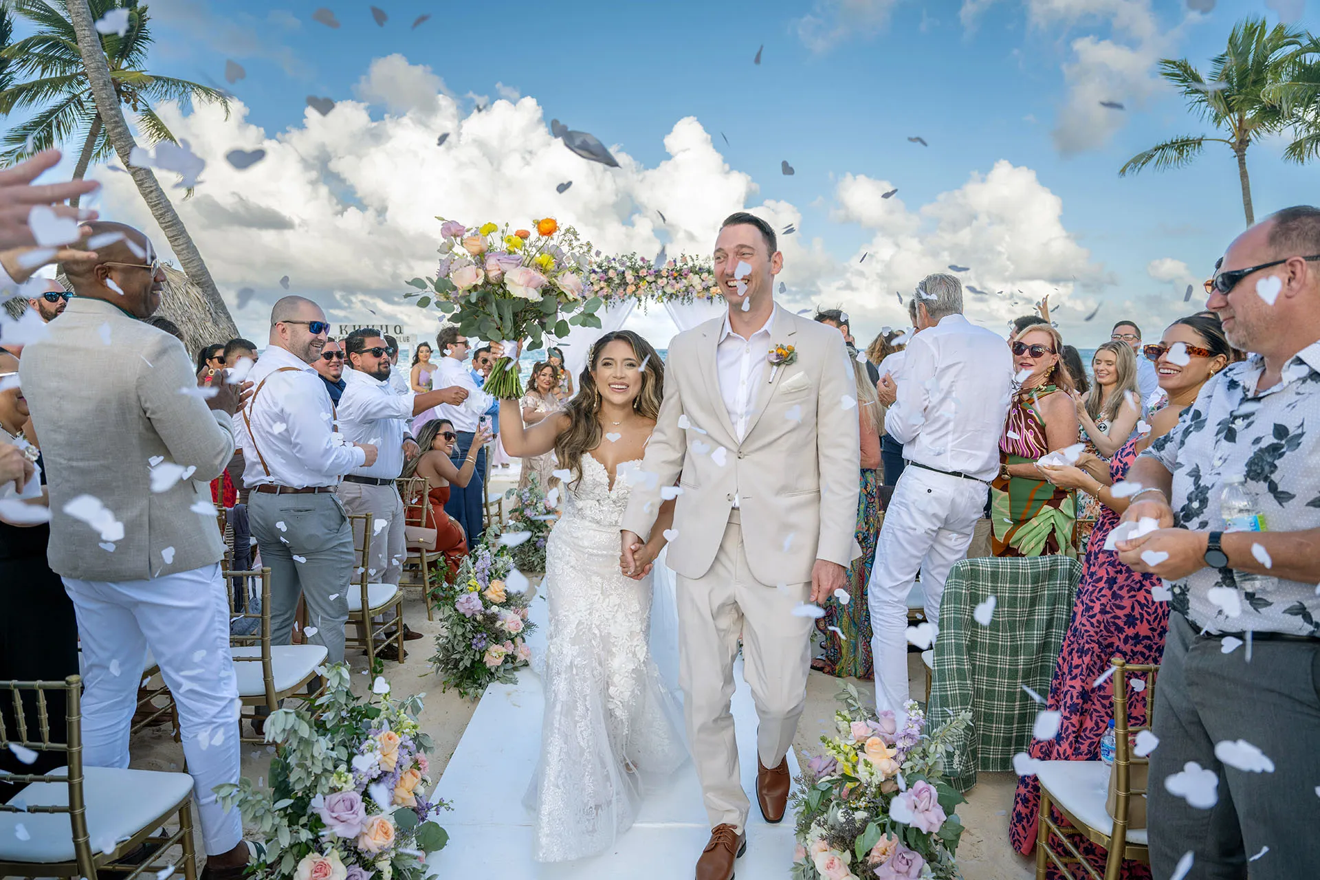 Cassandra and Matthew smiling as guests throw confetti during their Kukua exit Cassandra and Matthew smiling as guests throw confetti during their Kukua exit
