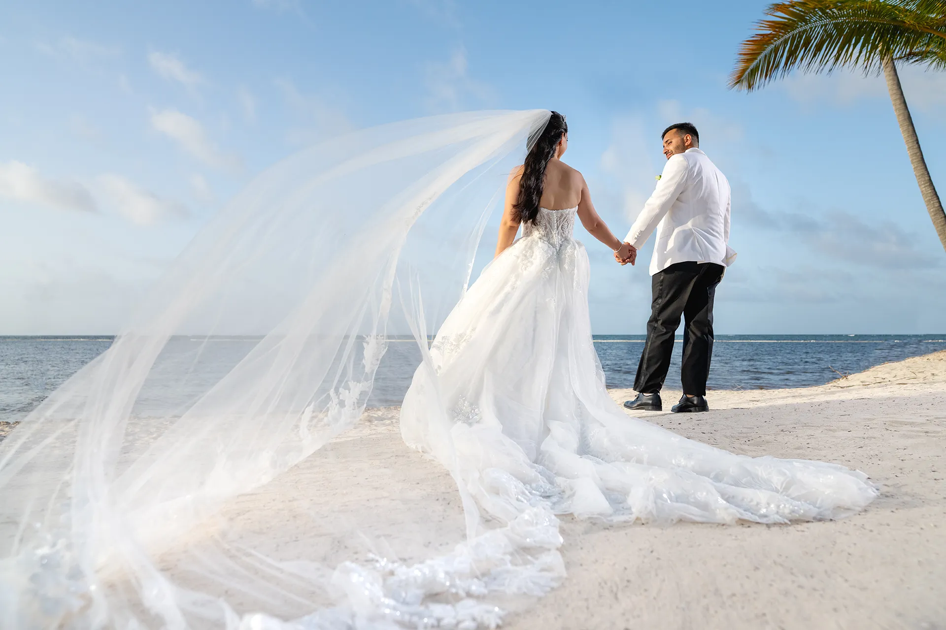 Wedding couple on the beach with long flowing veil at Pearl Beach Club Punta Cana