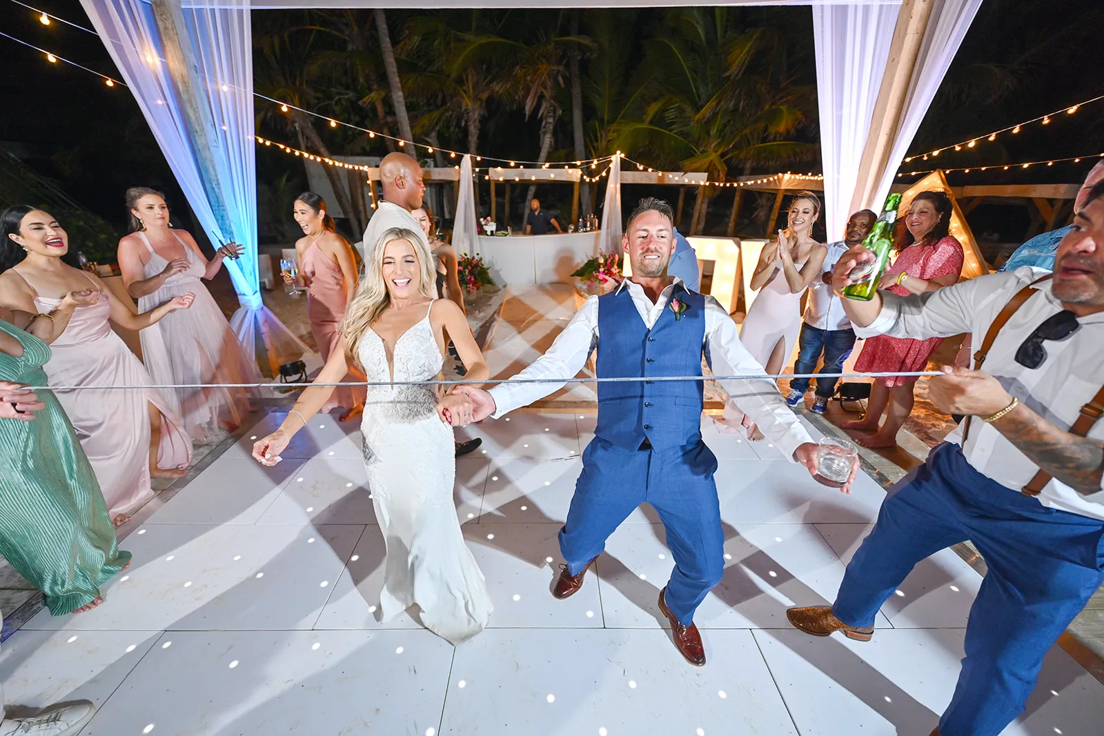 Bride and groom taking part in a limbo competition on the dance floor at their Punta Cana wedding