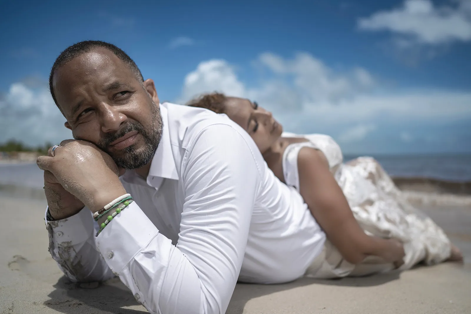 Quiana and Julio lying on the sand in white after their Trash the Dress session at Macao Beach Quiana and Julio lying on the sand in white after their Trash the Dress session at Macao Beach