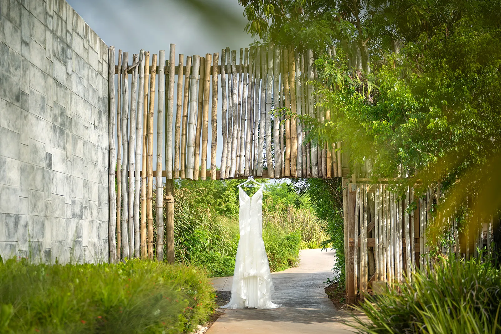 dreams-macao-beach-wedding-dress Frankeesue's wedding dress hanging beneath a bamboo garden entrance at Dreams Macao Beach